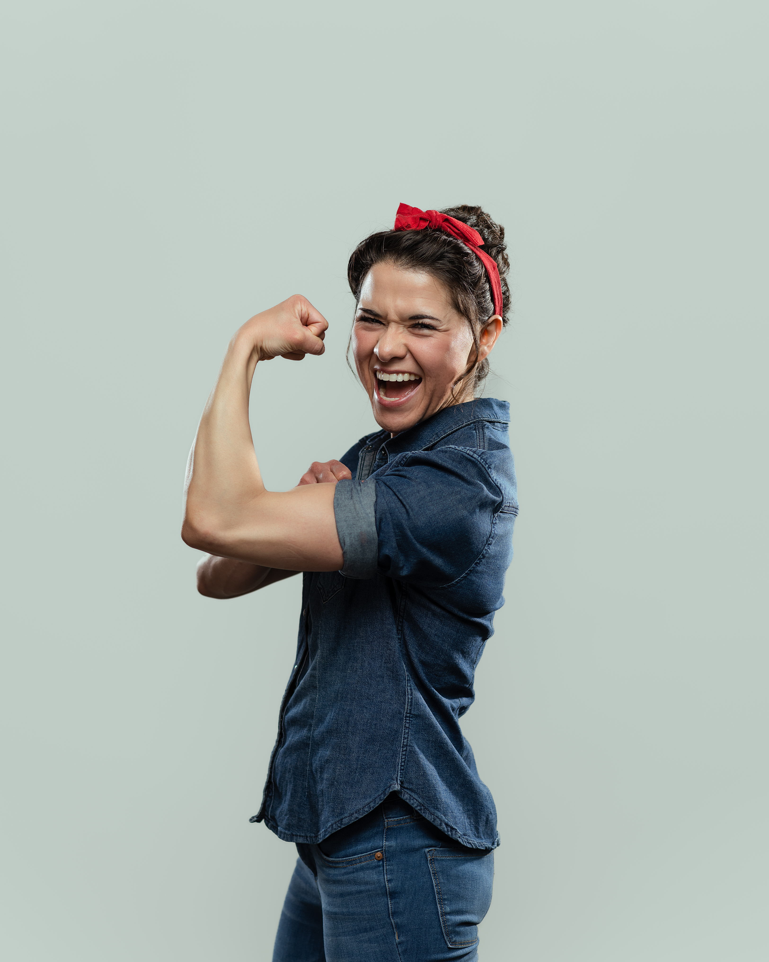 creative portrait of a woman dressed and posing like strong woman Rosie the Riveter