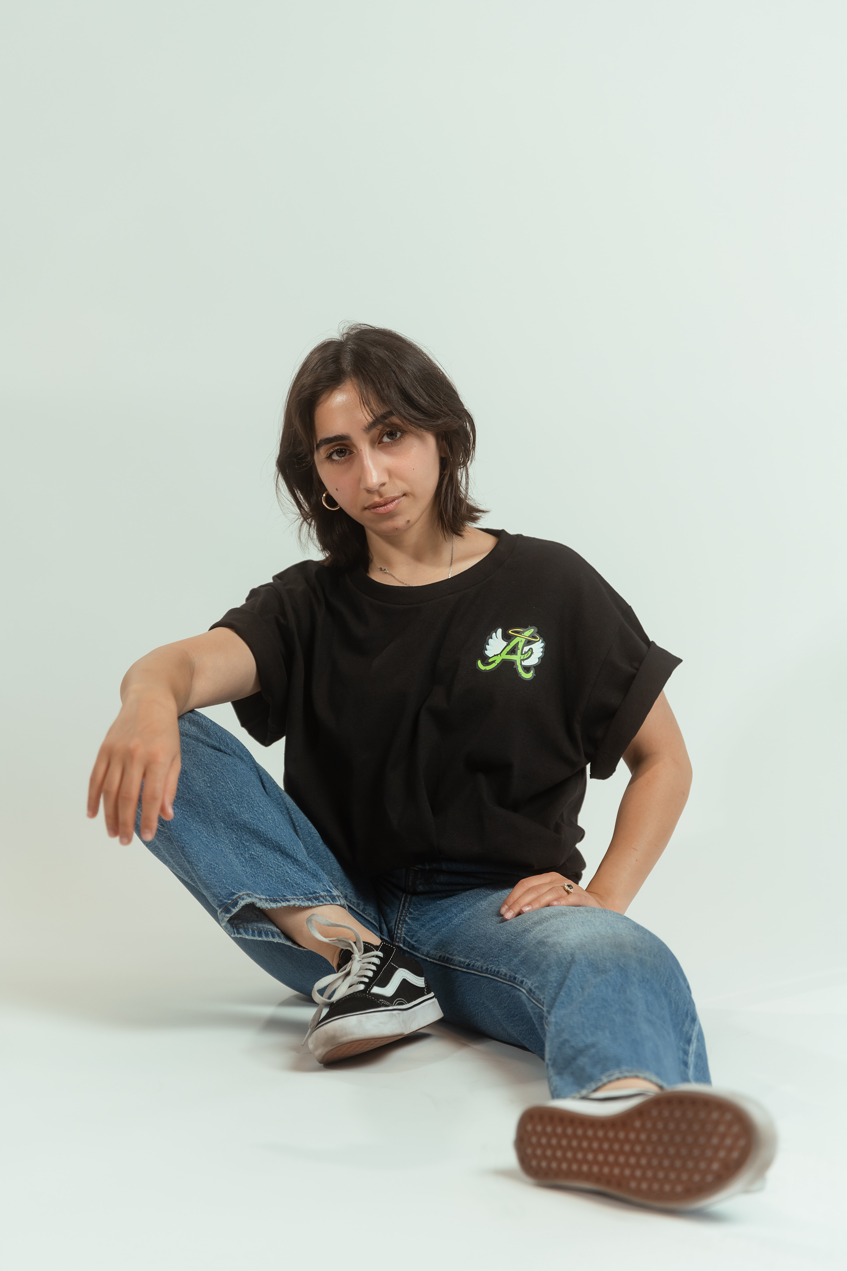 Woman posing in Desert Angel Embroidery T-shirt in Arizona studio, product photography.
