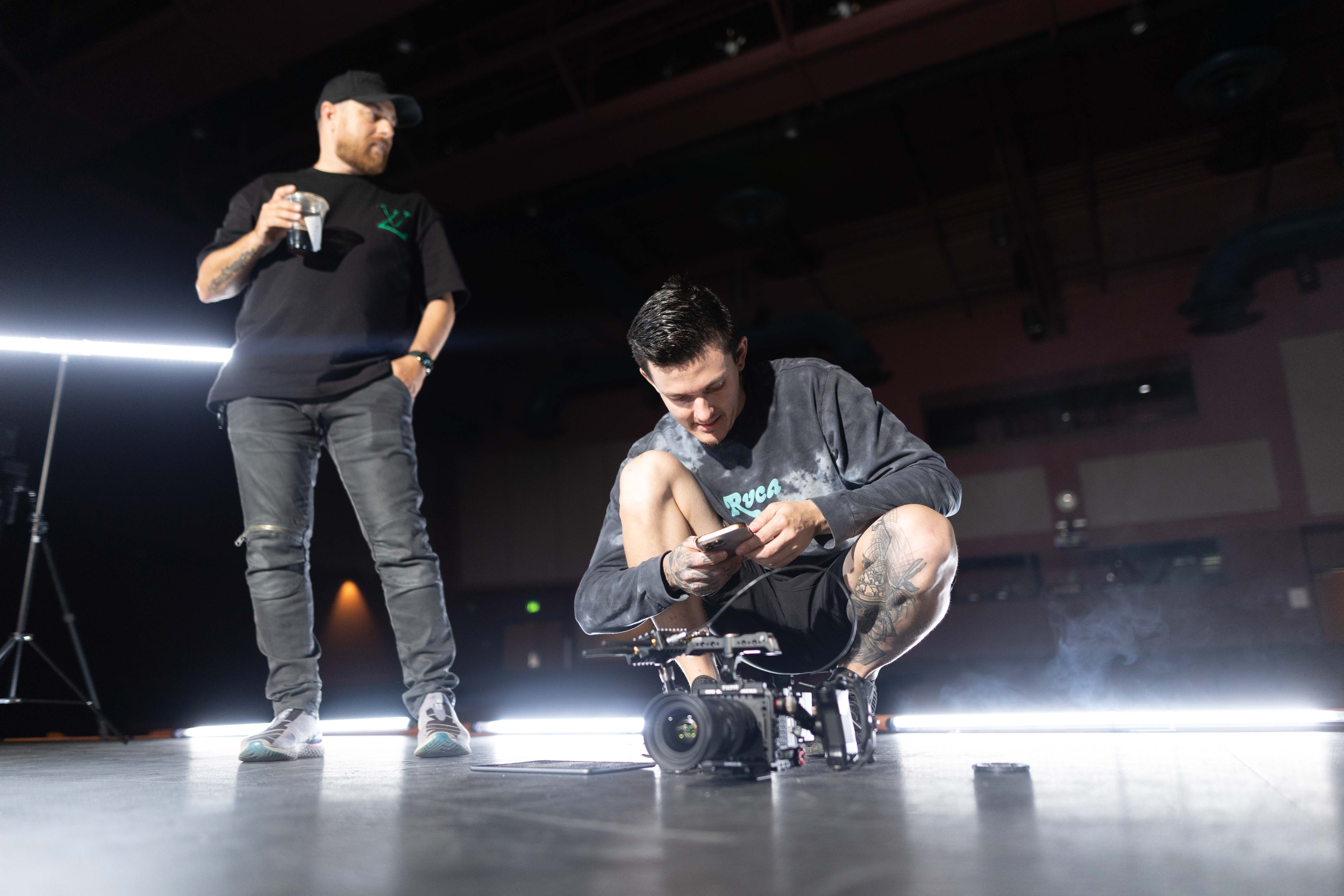Low-angle behind-the-scenes shot of the director checking notes on set of the music video for Dominique Ilie's song: Complicated