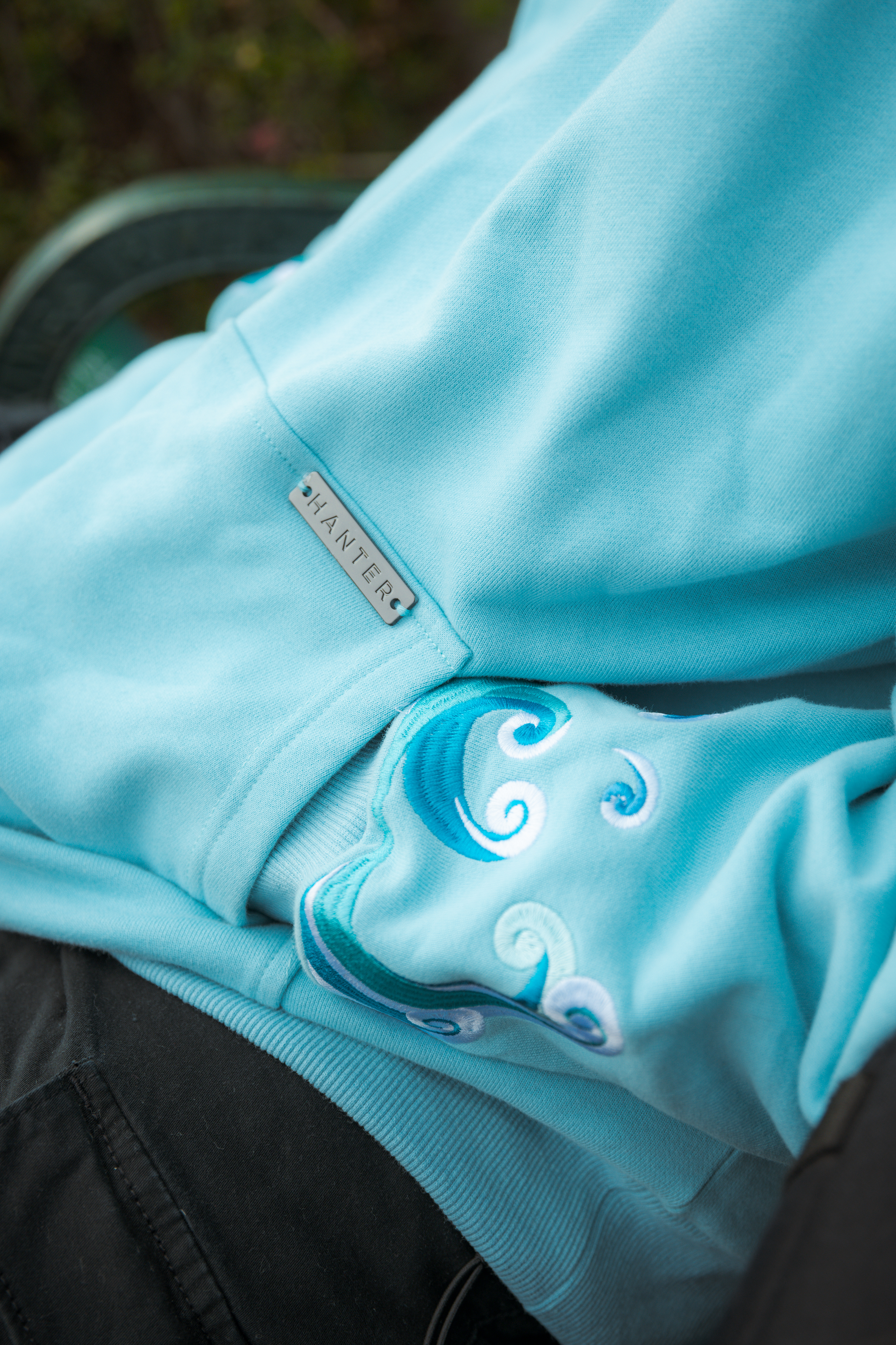 Close-up of Hanter hoodie fabric, logo, and design details.
