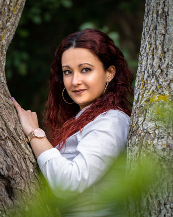 Woman portrait behind a tree in a white shirt