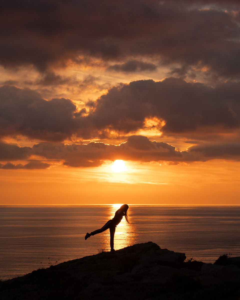 Woman yoga with sunset in background