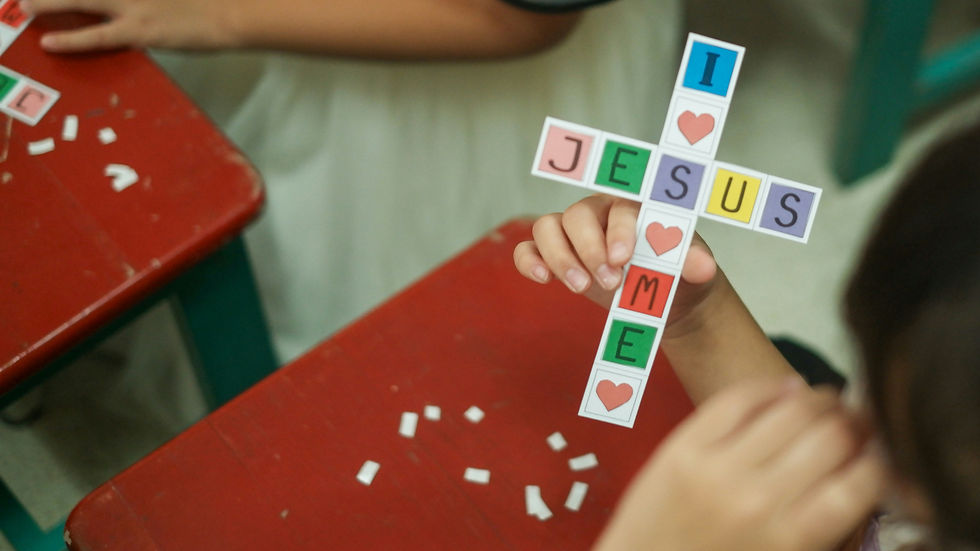 A child is making a handicraft in the shape of a cross and saying I love Jesus_edited.jpg