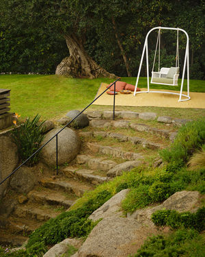 ESCALA Swing with base beside stone garden steps