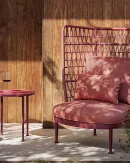 CURIO Highback Armchair positioned on a stylish outdoor deck with lush greenery.