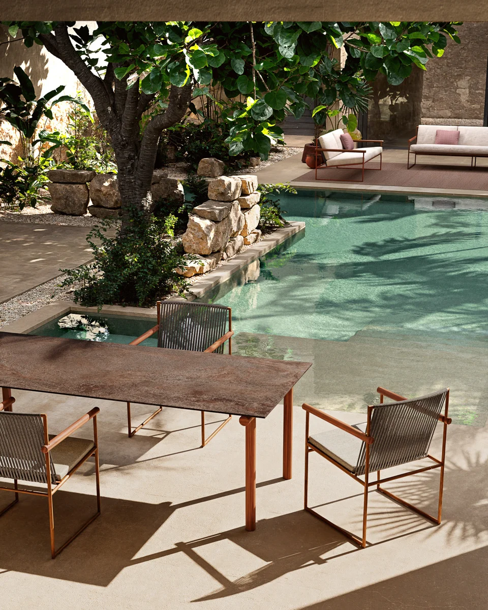 Atmosphera Pipe dining chairs around a teak table beside the pool