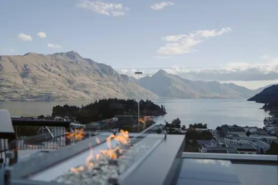 Balcony fire feature at The Carlin Hotel with panoramic views across Lake Whakatipu and Queenstown’s skyline.