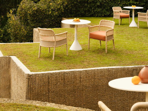 ESCALA Dining Armchairs arranged with outdoor tables on a lawn