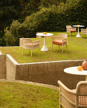 ESCALA Dining Armchairs arranged with outdoor tables on a lawn