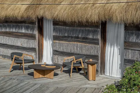 KNIT outdoor lounge armchair in teak and woven rope in an outdoor setting