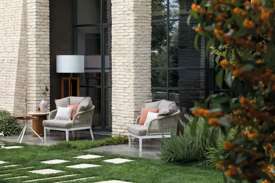 DREAM outdoor armchair featuring a curved rope‑woven backrest, durable aluminium structure, and weather‑resistant cushions.