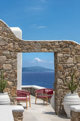 KILT outdoor dining armchair in teak, styled around an outdoor dining table