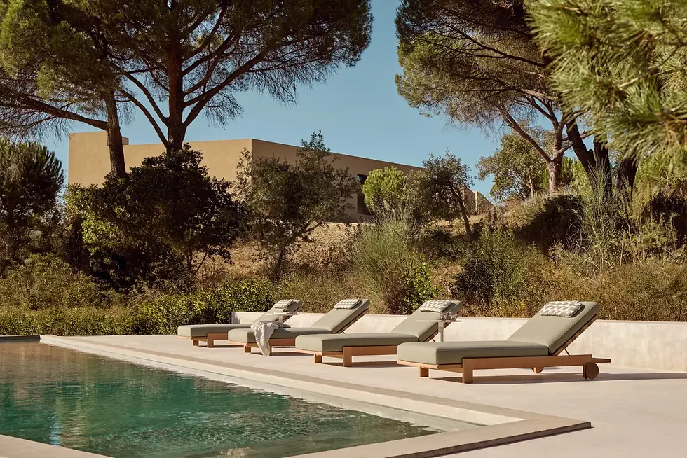 Kubik sun loungers beside a pool, showing weatherproof outdoor furniture in a refined Mediterranean setting.