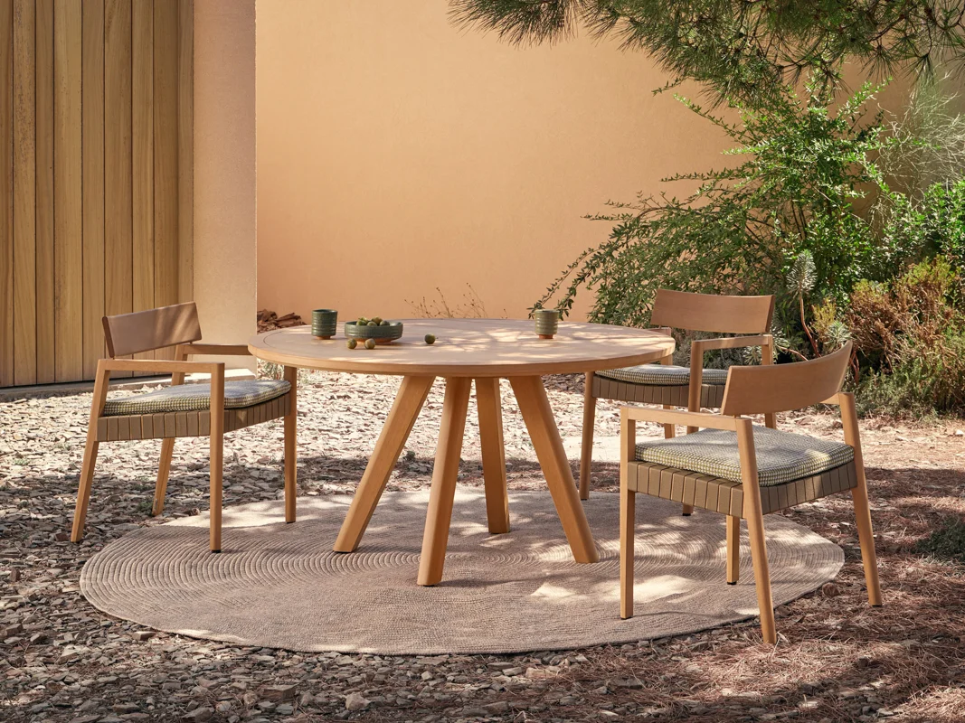 Kubik round outdoor dining table and chairs creating a cohesive dining zone in a garden courtyard.