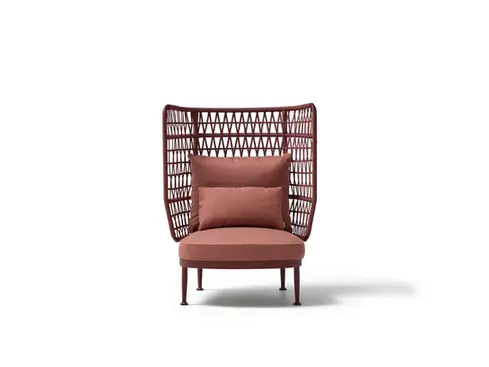 Wide studio shot of the CURIO Armchair with braided rope backrest and plush cushions.