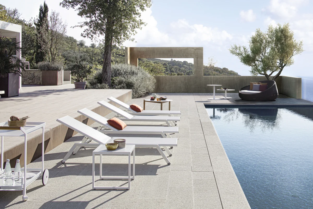 A bar trolley and sun loungers in a luxurious residential poolside setting