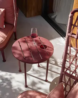 CURIO Highback Armchair and Side Table positioned on a stylish outdoor deck with lush greenery.