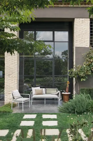 AIR Sofa and Armchair set styled on a modern patio with garden backdrop