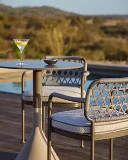 CURIO Dining Chairs positioned poolside on a stylish outdoor deck. 