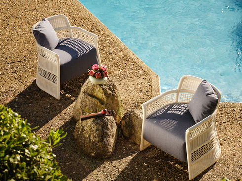 Pair of white ESCALA Lounge Chairs arranged by the pool