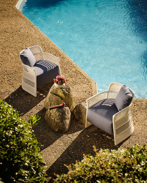 Pair of white ESCALA Lounge Chairs arranged by the pool