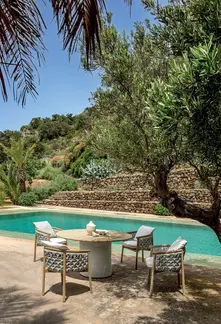 PATIO round outdoor dining table and dining chairs styled in an outdoor dining space