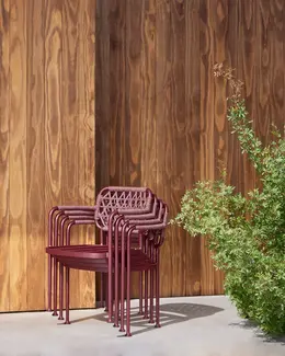 Stacked CURIO Dining Chairs positioned on a stylish outdoor deck.