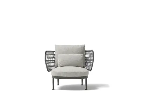 Wide studio shot of the CURIO Armchair with braided rope backrest and plush cushions.