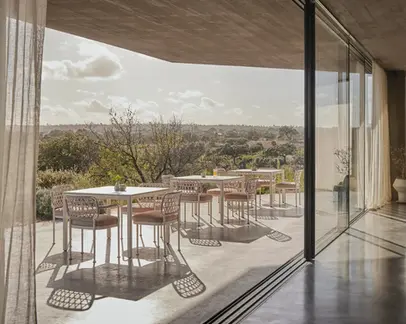 CURIO Dining Chairs positioned on a stylish outdoor deck at sunset.