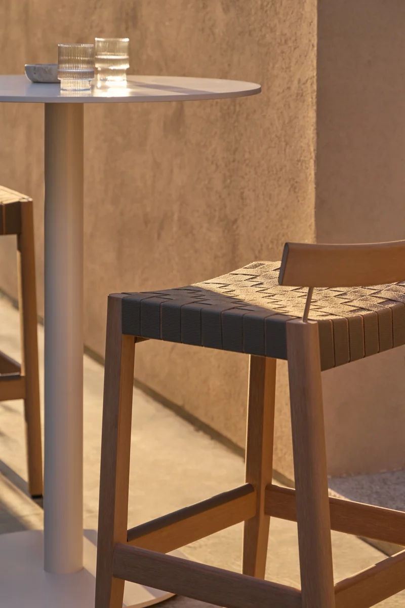 Close-up of Kubik outdoor bar stool with woven seat and warm TechTeak frame.