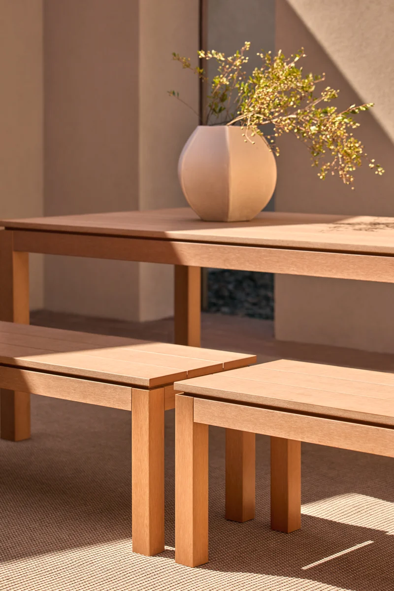 Close-up of Kubik outdoor dining table and bench seating, showing refined timber-look detailing.