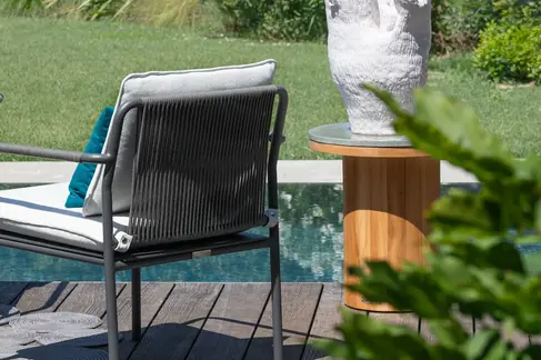 Rear view of AIR Armchair by poolside deck with garden landscape
