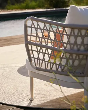 CURIO Armchairs positioned on a stylish outdoor patio with lush greenery.