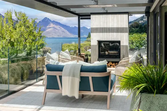 Coco Wolf bench seating with layered green cushions on the ROKI terrace, backdropped by alpine trees and mountains.