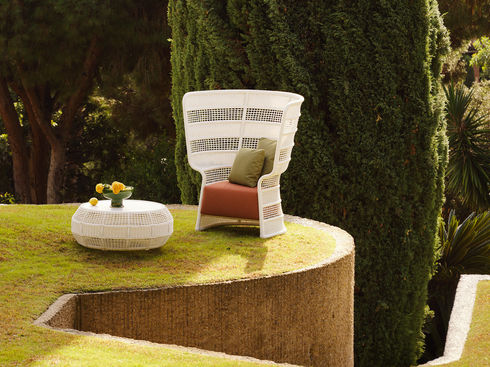 White ESCALA High Back Lounge Chair beside a low outdoor coffee table