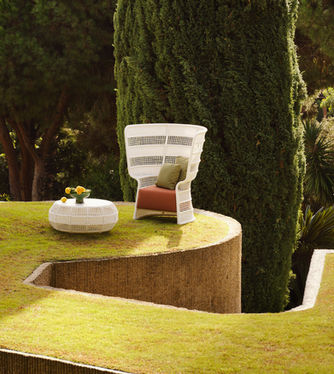 White ESCALA High Back Lounge Chair beside a low outdoor coffee table