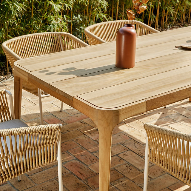 Modern outdoor dining furniture with braided rope chairs and neutral tones, suited to refined outdoor spaces