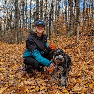 Emily and her puppy on a walk in the woods