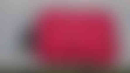 Inflatable pillow blown up, beside a pair of sunglasses for scale