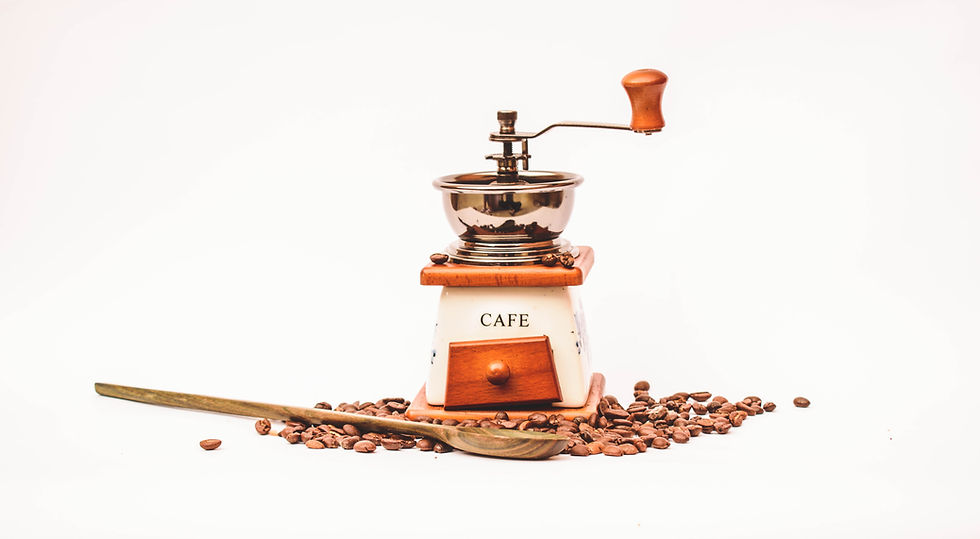 Molino de café sobre granos de café.