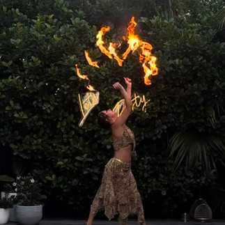 Fire performer dancing with fire fans at central coast party event