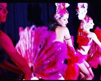 showgirls on stage at sydney event dressed in pink and white feathered costumes