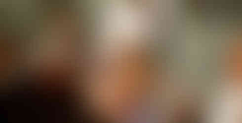 Burlesque dancer at wedding event posing with guests laughing