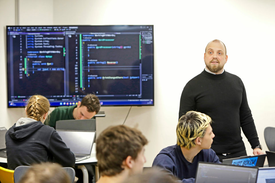 Učitel a studenti ve třídě.