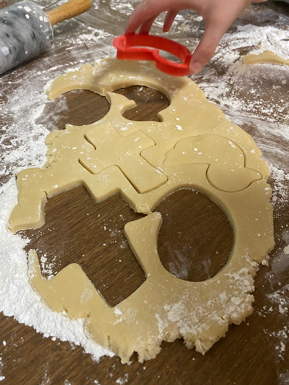 Eye-level view of rolled out cookie dough with Easter cookie cutters on a floured surface