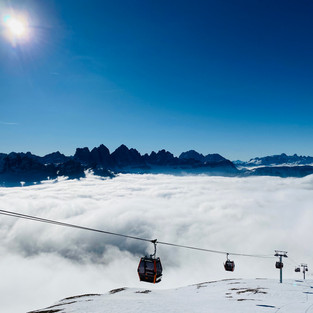 Verschneite Skipiste mit Gondeln und blauem Himmel