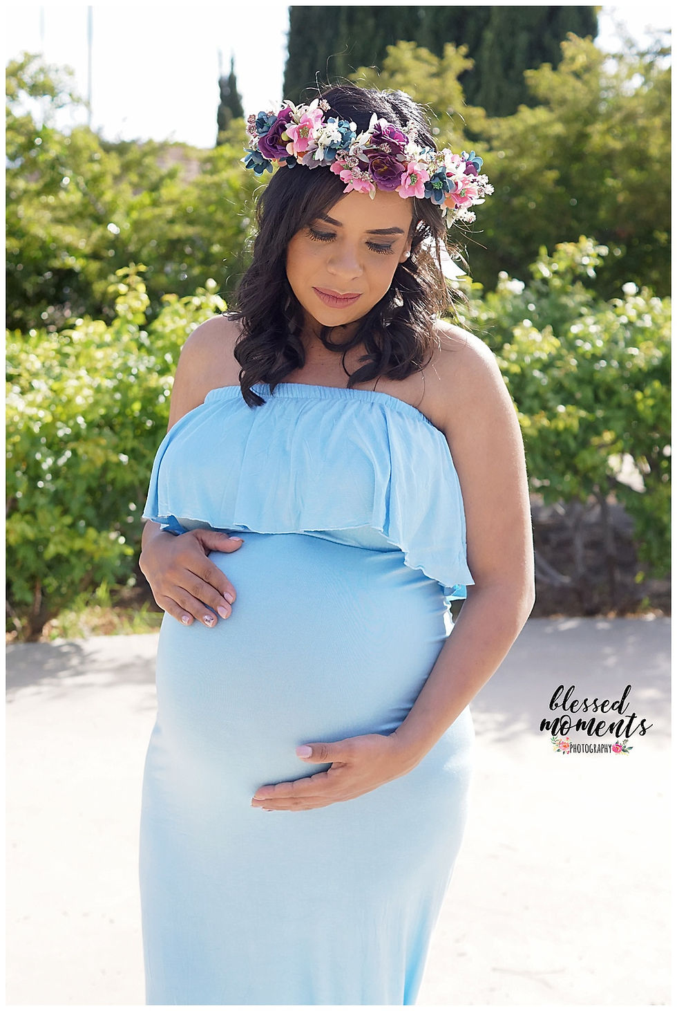 Maternity photo taken in El Paso Rose Garden with baby blue boho maternity gown