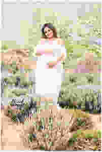 Maternity photo with mama wearing a white lace gown. Photo taken in Railyard park Santa Fe