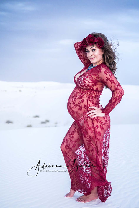 Burgundy lace short maternity gown with long sleeves, expectant mother posing barefoot in White Sands with floral headpiece.