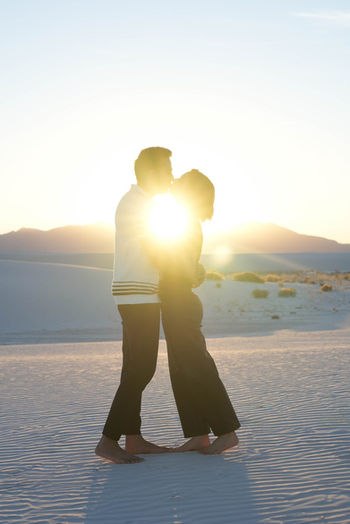 Couple kissing in the sunlight during a portrait session at White Sands National Park